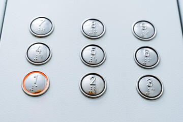 A close shot of burning elevator buttons. First floor. Call the elevator cabin. Minimalistic design of buttons