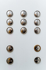 A close shot of the multi-function elevator button panel. On the button of the inscription for the...