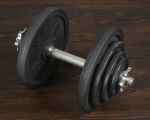 black heavy dumbbell on dark wooden floor