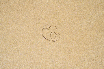 Hand-drawn shape of two heart on sand tropical beach. valentines day. Holiday concept. Creative, background, copy space, travel, summer. Flat lay