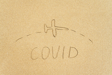 Drawing of airplane flying over the word covid on the sandy beach. Travel hope concept. Openning season