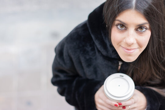 Woman Looking Up With A Take Away Coffee