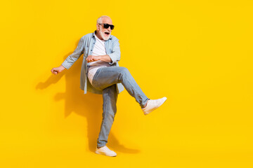 Fototapeta na wymiar Full length body size view of attractive cheerful crazy grey-haired man dancing having fun isolated over bright yellow color background