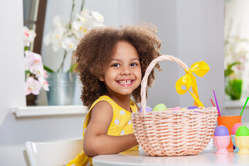 Smilling Little Black girl with basket full of painted Easter eggs