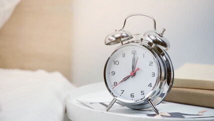 silver retro alarm clock showing eight am