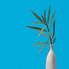 Green oleander branch over blue background