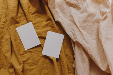 Blank paper invitation cards with copy space on neutral pastel elegant ginger and peach linen...