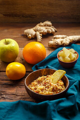 Couscous masfouf with dried fruits and nuts in a plate on a blue napkin on a wooden table next to a spoon.