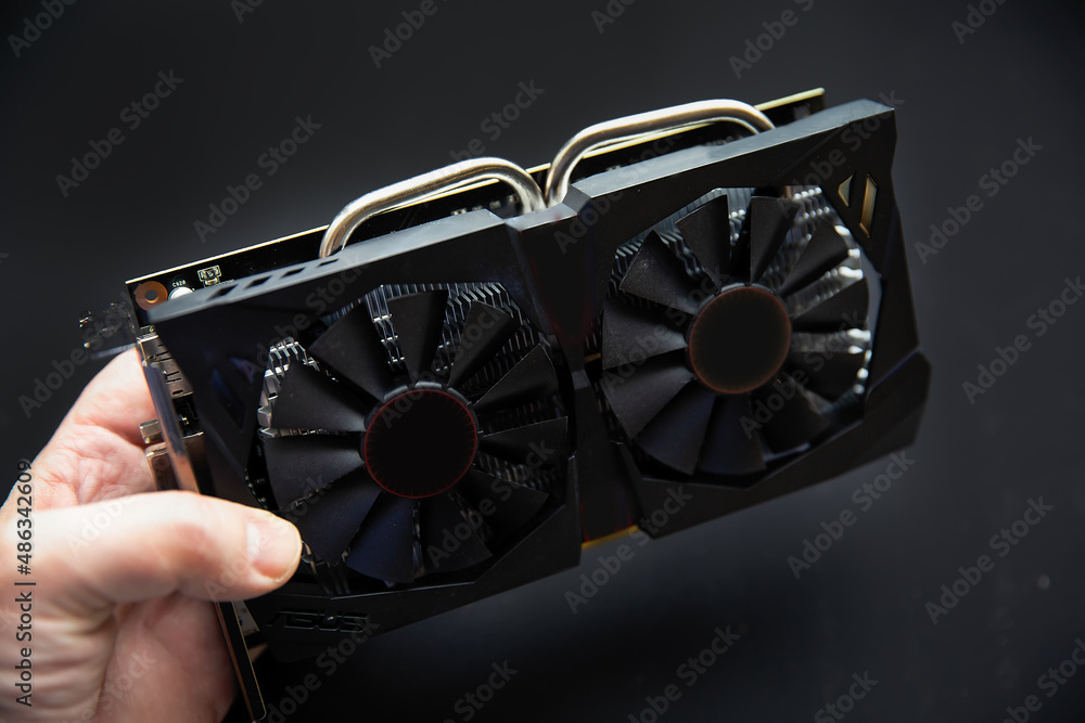 Poster powerful video game card in hand for installation in a computer. video card for mining and graphics 