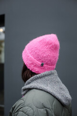 
Woman wearing a homemade cerise hat in hot pink or fuchsia on a gray background