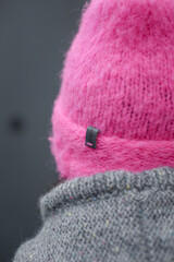 
Woman wearing a homemade cerise hat in hot pink or fuchsia on a gray background