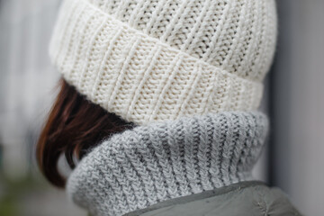 Fototapeta na wymiar Close-up shot of a handmade knitted wool hat in white color. Fashionable actual hat for the autumn-winter-spring season. Alpaca wool