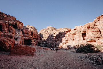 Fototapeta na wymiar Ruins of the ancient city of Petra in Jordan. Red sandstone mountains on a clear day. Caves in the rock. Colorful photos.