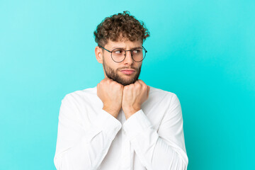 Fototapeta premium Young handsome caucasian man isolated on blue background With glasses and tired