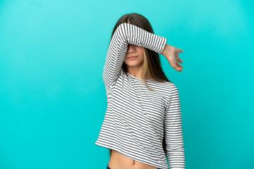 Little girl over isolated blue background covering eyes by hands