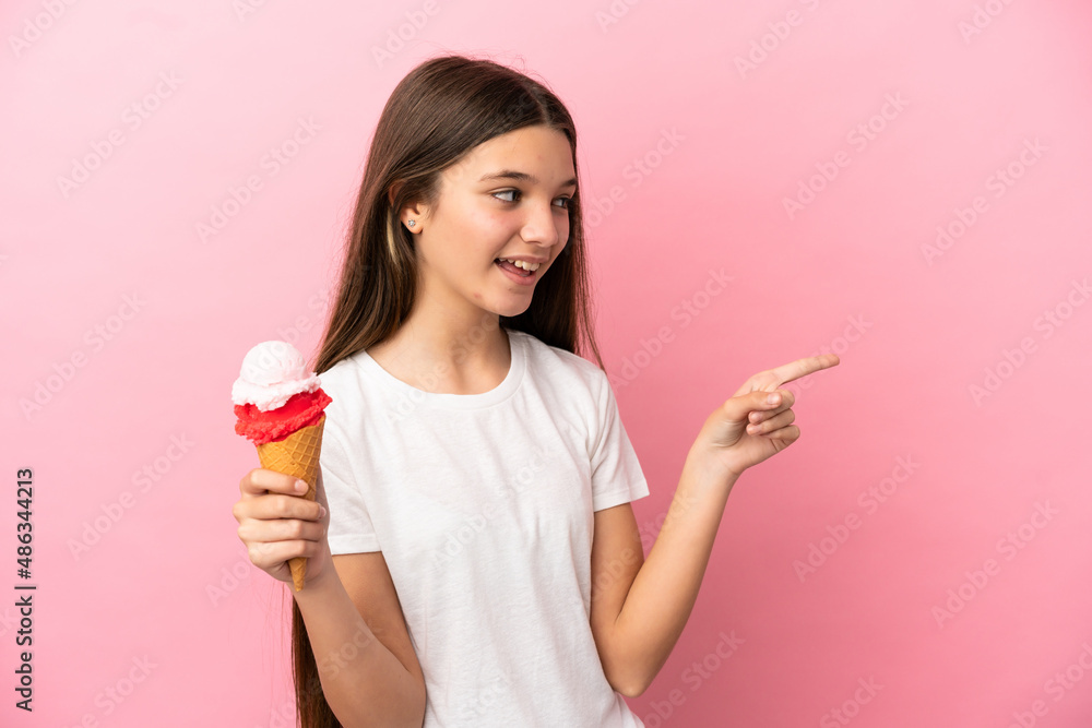 Canvas Prints Little girl with a cornet ice cream over isolated pink background pointing finger to the side and presenting a product