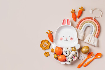 Easter  decoration with cute plate in the shape of a bunny with  Easter eggs, candy, carrot and flowers. Happy Easter concept. Idea for Easter dinner