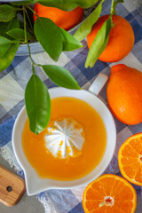 Freshly squeezed mandarin orange juice with glass pitcher, glass jars and aluminum reusable straws.