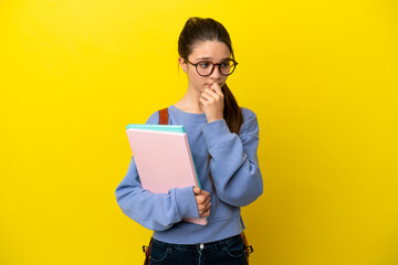 Student kid woman over isolated yellow background having doubts