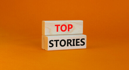 Top stories symbol. Concept words Top stories on wooden blocks on a beautiful orange table orange background. Business story and top stories concept, copy space.