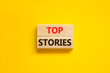 Top stories symbol. Concept words Top stories on wooden blocks on a beautiful yellow table yellow background. Business story and top stories concept, copy space.