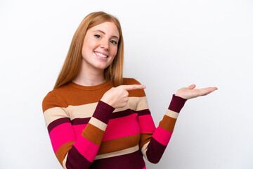 Young redhead woman isolated on white background holding copyspace imaginary on the palm to insert...