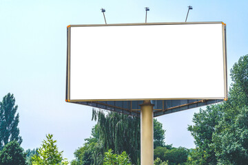 Blank billboard mockup with white screen. Against the backdrop of nature and blue sky. Business concept. Copy space banner for advertising.