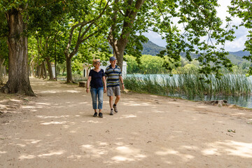Fototapeta na wymiar Senior couple hiking along the lake of Banyoles, Catalonia, Spain