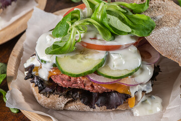 Healthy vegan burger with fresh vegetables and yogurt sauce