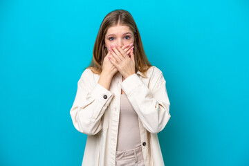 Teenager Russian girl isolated on blue background covering mouth with hands