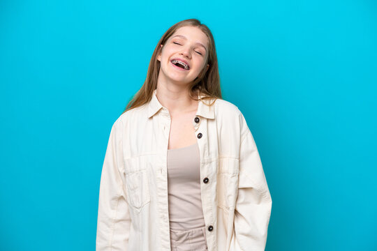Teenager Russian girl isolated on blue background laughing