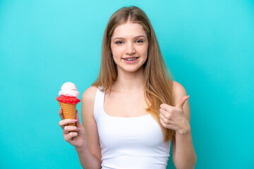 Teenager Russian girl with a cornet ice cream isolated on blue background with thumbs up because something good has happened