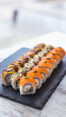 Sushi Set nigiri and sushi rolls on black stone slate plate board