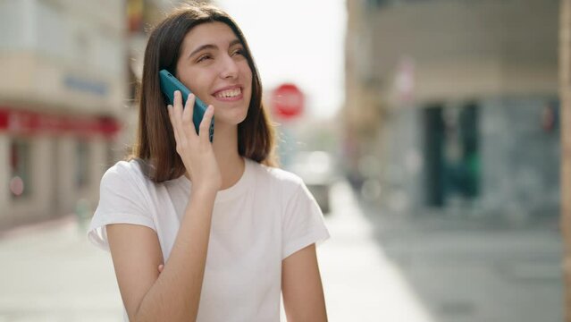 Young hispanic girl smiling confident talking on the smartphone at street