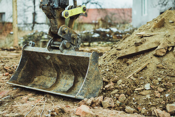 Digger bucket with rubble. House demolition. 