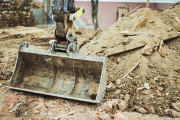 Digger bucket with rubble. House demolition. 