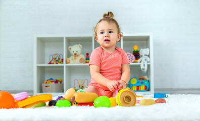 Baby plays with toys in her room. Selective focus.