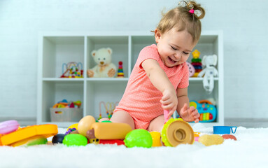 Baby plays with toys in her room. Selective focus.