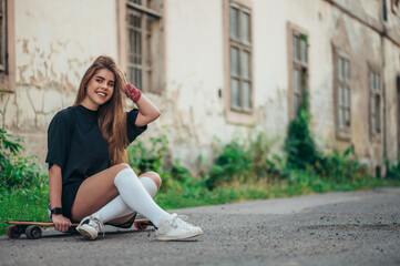 Fototapeta na wymiar Young woman sitting on her longobard on the road