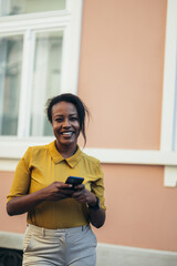 African american woman using a smartphone while walking in the city