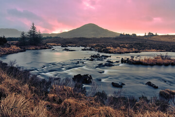 Beautiful orange sunrise landscape scenery with river stream and mountains at Derryclare natural reserve in Connemara National park, county Galway, Ireland 
