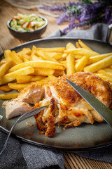 Fried chicken breast stuffed with bacon and cheese served with chips and salad.