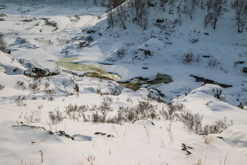 Winter landscape with trees and sky from the high rocky river bank
