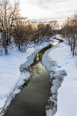 The Vokhonka river in winter in the historical center of the small district town of Pavlovsky Posad, Russia