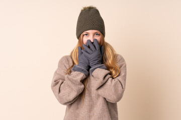 Obraz premium Teenager Ukrainian girl with winter hat isolated on beige background with surprise facial expression