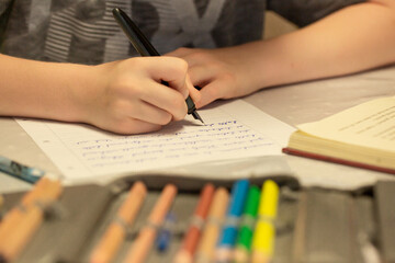 junge, der Füllfederhalter Wörter in grauem T-Shirt schreibt