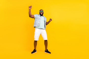 Full length body size view of attractive cool cheerful guy rejoicing dancing having fun isolated over vivid yellow color background
