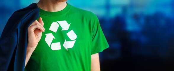Man showing chest with Recycling Symbol logo on green t-shirt. Corporate office on blurred background. Hero business man with recycling logo symbol shirt against climate. Environmental concept.