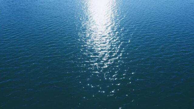 ドローン撮影　太陽のきらめく海面スレスレを飛行する素材　4K UHD