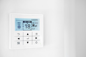 Mounted on wall, climate control show 18 degrees indoor, remote air-conditioner inside smart home...